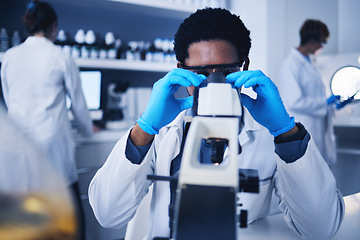 Image showing Microscope, science and black man working on test in laboratory of medical research analysis. Scientist, microbiology and biotechnology technician planning investigation, innovation and dna pathology