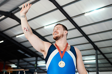 Image showing Man, medal celebration and winning smile with wave, sports and hand in air at competition with pride. Champion athlete, happy and winner with gold, celebrate or success in global gymnastics contest