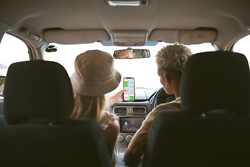 Image showing Rear view of a mixed race man and caucasian girlfriend in a car, travel using a smartphone gps to navigate their way to a location while sitting in a vehicle and couple road trip together in Canada