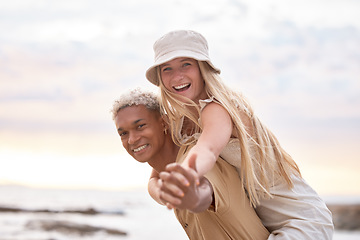 Image showing Closeup portrait of an young affectionate mixed race couple standing on the beach and smiling during sunset outdoors. Hispanic man and caucasian woman showing love and affection on a romantic date at