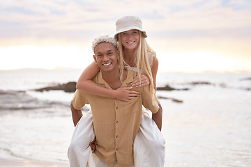 Image showing Closeup portrait of an young affectionate mixed race couple standing on the beach and smiling during sunset outdoors. Hispanic man and caucasian woman showing love and affection on a romantic date at