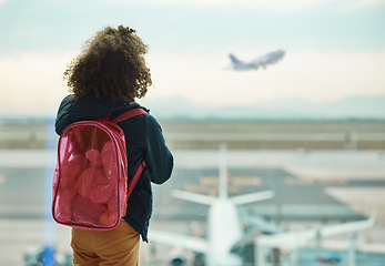 Image showing Girl child, looking and airport window for greeting, goodbye and focus for airplane, international transport or travel. Kid, back and watch takeoff by glass for global immigration, young and African