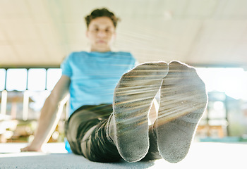 Image showing Feet, fitness and man doing a stretching exercise before training in gym or sport center. Sports, health and male athlete doing leg warm up workout for flexibility and balance for gymnastics practice