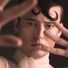 Image showing Beauty portrait of transgender man isolated on dark background for creative and queer fashion aesthetic. Young lgbtq model or gay person face with cosmetics, makeup and hands for art style in studio