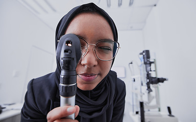 Image showing Vision, optometrist and woman with retinoscope in hospital for examination. Eye test, healthcare and muslim doctor or ophthalmologist with equipment tool for eyecare, health and wellness in clinic.
