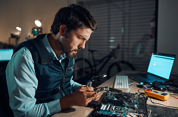 Image showing Man, motherboard and magnifying glass at repair workshop in night for maintenance, computer tech or industry with focus. Technician, circuit and it job in dark with electronics, engineering and tools