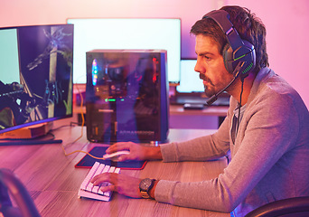 Image showing Computer gamer, man and headphones for esports, online games and virtual competition in dark room. Gaming guy, rpg player and video game on headset in neon lighting, pc technology and cyber internet