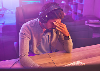 Image showing Stress, gamer or man with headache from loss, fail or online competition tournament anxiety in room. Neon, sad or depression male for gaming mental health, live stream disappointment or esport glitch