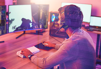 Image showing Computer gaming, man and headphones for esports, online games or virtual competition in dark room. Gamer guy, digital player and live streaming on headset in neon lighting, technology or rpg streamer