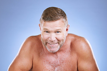 Image showing Portrait, skincare and hygiene with a mature man in studio on a blue background for cleaning or beauty. Face, wellness and health with a handsome older male posing to promote natural skin treatment