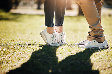 Image showing Shoes, grass and love with a couple outdoor together, kissing for romance, dating or affection in summer. Nature, field or feet with a man and woman on a romantic date for relationship bonding