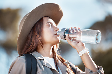 Image showing Hiking, fitness and woman drinking water for outdoor adventure, nature walking with nutrition, health and wellness. Liquid bottle for tired young person on journey, sports and trekking in summer