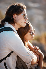 Image showing Love, outdoor and couple hugging while on a hike on a mountain while on vacation or weekend trip. Romance, happy and young man embracing his girlfriend from behind while trekking together on holiday.