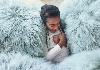 Image showing Comfy, happy and girl on a pillow to relax, playing and laughing from above in a house. Smile, laughing and carefree child cozy in the lounge being playful, funny and relaxing on a soft sofa