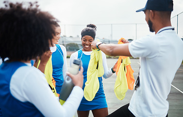 Image showing Coach, vest or team in netball training game, workout or exercise for a match on sports court. Teamwork, fitness group or manager giving bibs to excited athlete girls with happy smile in practice