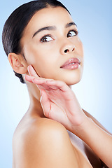 Image showing Skincare, woman and hand on face in studio for beauty, wellness and cosmetic grooming on blue background. Skin, glow and girl model relax with smooth, soft and dermatology satisfaction while isolated