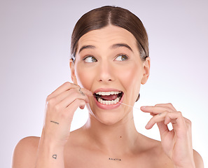 Image showing Flossing, woman and teeth in studio for beauty, healthy dental wellness and skincare on background. Female model, tooth floss and cleaning mouth for fresh breath, oral maintenance or cosmetic results