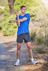 Image showing Stretching arms, fitness and man in nature getting ready for running, exercise or training. Sports health, thinking and male athlete warm up or prepare to start cardio, exercising or jog for wellness