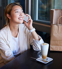 Image showing Phone call, shopping bag and Asian woman in cafe with coffee talking, chatting and social conversation. Communication, fashion and happy girl on smartphone for discount news, retail and sale in mall