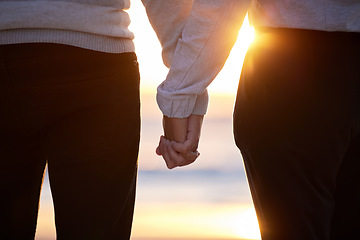Image showing Beach, couple and holding hands at sunset for love and trust or commitment and support on vacation. Hand of man and woman together on holiday at sea to relax, travel and connect in nature with care