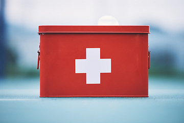 Image showing First aid, box and medical equipment for health emergency, response and treatment kit isolated in a blurred background. Red, cross and safety or medicine on a table for fast healthcare or cure