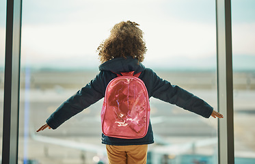 Image showing Girl kid, looking and airport window for greeting, goodbye and flying on airplane, international transport or travel. Child, back and watch takeoff by glass for global immigration, young and playing