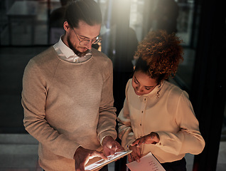 Image showing Man, tablet and office in night with black woman, discussion or web design with check, decision or strategy. Teamwork, it goals and ux designer group for ideas, vision and dark workplace for analysis