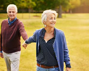 Image showing Romance, retirement and old couple holding hands in field, walking in nature and happy smile on grass. Peace, senior man and woman on romantic walk in park, health and love on holiday in countryside.