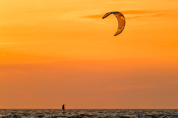 Image showing Kiteboarding kitesurfing kiteboarder kitesurfer kites silhouette in the ocean on sunset