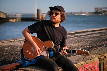 Image showing Street musician playing electric guitar in the street