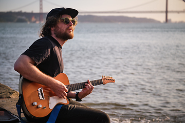 Image showing Street musician playing electric guitar in the street