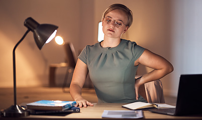 Image showing Woman, office and night with back pain, burnout and stress at desk for overtime, fatigue and tired. Young corporate executive, manager and muscle strain in dark workplace, frustrated and exhausted