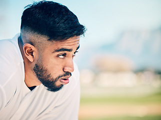 Image showing Tired, breathing and sports man at a field for training, break and breathing exercise on blurred background. Athletic, sports and indian guy stop to breathe after exercise, workout or match practice