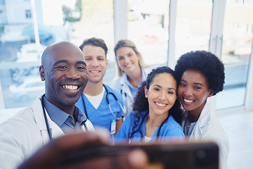 Image showing Healthcare, team and selfie by doctors at hospital, happy and proud , smile and bond on blurred background. Medical, diversity and group pose for photo, profile picture or website homepage update