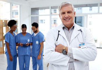 Image showing Senior, doctor and man at hospital, leadership and healthcare with smile in portrait, cardio surgeon and arms crossed. Medical professional, cardiovascular health and male, happy and team leader