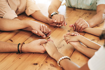 Image showing Holding hands, praying and support by group of people or family together in unity, spiritual and faith in God and gratitude. Closeup, Solidarity, religion and hope in a home due to grief