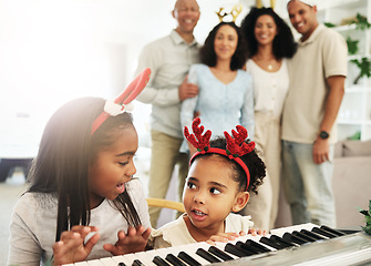 Image showing Christmas, black family and kids playing the piano together in their home for music or festive celebration. Children, december and holiday with girl sister siblings in a house to play an instrument
