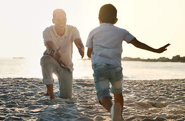 Image showing Fun, playful and father with a child at the beach for bonding, quality time and playing in Spain. Freedom, happy and smiling father catching a running boy at the ocean for love, care and enjoyment