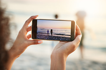 Image showing Phone, photograph and beach with a woman in nature, recording her playing kids by the ocean outdoor. Mobile, family and sunset with a parent taking a picture of her kids on the sand at the sea