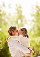 Image showing Nature, love and couple kiss for happy, quality time and bonding on weekend, vacation and holiday together. Dating, relationship and young mana nd woman hugging, kissing and romantic embrace in park