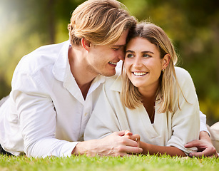 Image showing Love, grass and nature with a couple lying together on a field for romance or affection during a date. Spring, park or peace with a young male and female bonding while enjoying a summer picnic