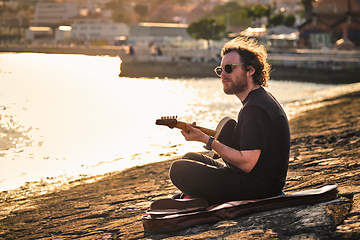 Image showing Street musician playing electric guitar in the street