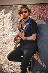 Image showing Street musician playing electric guitar in the street