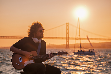 Image showing Street musician playing electric guitar in the street