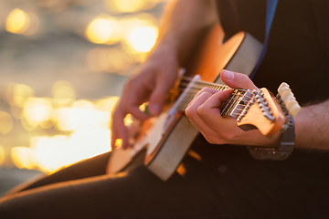 Image showing Street musician playing electric guitar hands close up