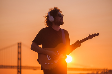 Image showing Street musician playing electric guitar in the street