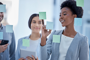 Image showing Black woman, writing and planning schedule with team on glass board for brainstorming meeting at office. Happy African American female in teamwork collaboration, tasks or sticky note for project plan