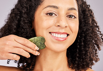 Image showing Face portrait, skincare and black woman with gua sha in studio isolated on a gray background. Dermatology, cosmetics and happy female model with tool, stone or crystal for healthy skin and wellness.