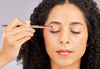 Image showing Face, makeup and black woman with eyeshadow brush in studio isolated on a gray background. Eyes closed, cosmetics and young female model with facial tool for beauty aesthetics, skincare and wellness.