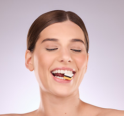 Image showing Licorice, happy woman eating and mouth with makeup and cosmetics in an isolated studio. White background, sweet food and candy snack product with hungry female model face with sugar for dessert